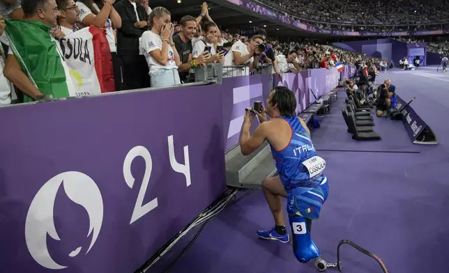 Italy's Alessandro Ossola asks her girlfriend to marry him after competing in the men's 100 m. T63 during the 2024 Paralympics, Sunday, Sept. 1, 2024, in Paris, France. (AP Photo/Christophe Ena)