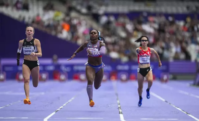 Brittni Mason from the U.S., centre, competes in the women's 100 m. T47 during the 2024 Paralympics, Tuesday, Sept. 3, 2024, in Paris, France. (AP Photo/Thibault Camus)