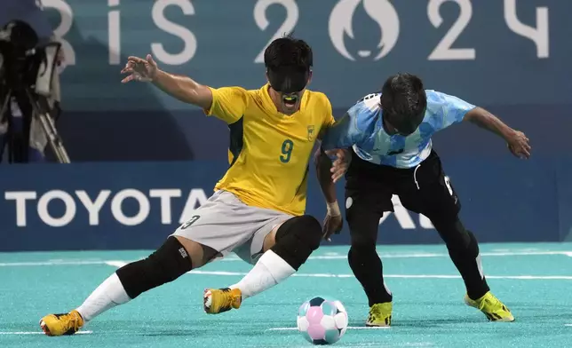 Brazil's Tiago da Silva, left, and Argentina's Osvaldo Fernandez fight for the ball during the semifinal blind football match between Argentina and Brazil at the 2024 Paralympics, Thursday, Sept. 5, 2024, in Paris, France. (AP Photo/Michel Euler)