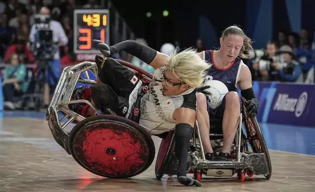 Japan's Daisuke Ikezaki falls after colliding with Sarah Adam of the U.S. during the wheelchair rugby gold medal match between Japan and the U.S. at the 2024 Paralympics, Monday, Sept. 2, 2024, in Paris, France. (AP Photo/Aurelien Morissard)