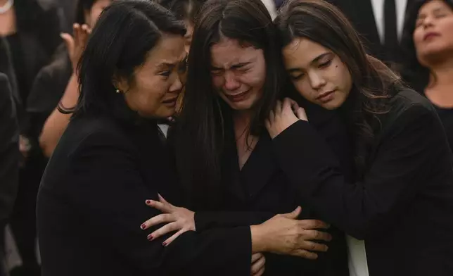 Keiko Fujimori, left, embraces her daughters Kiara, center, and Kaori during the funeral of her father, former President Alberto Fujimori, in Lima, Peru, Saturday, Sept. 14, 2024. (AP Photo/Guadalupe Pardo)