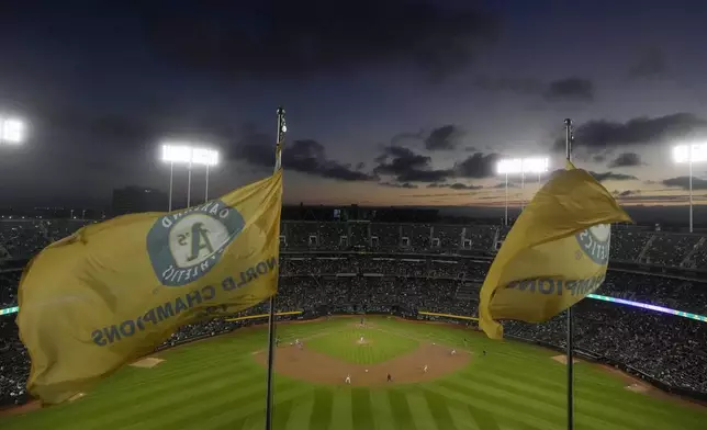 Fans at the Oakland Coliseum watch during the third inning of a baseball game between the Oakland Athletics and the Texas Rangers in Oakland, Calif., Wednesday, Sept. 25, 2024. (AP Photo/Jeff Chiu)