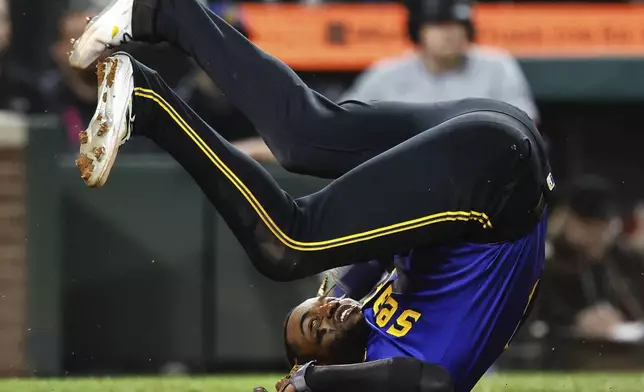 Seattle Mariners' Victor Robles tumbles past home after scoring on a Cal Raleigh sac fly during the seventh inning of a baseball game against the Texas Rangers, Friday, Sept. 13, 2024, in Seattle, (Dean Rutz/The Seattle Times via AP)