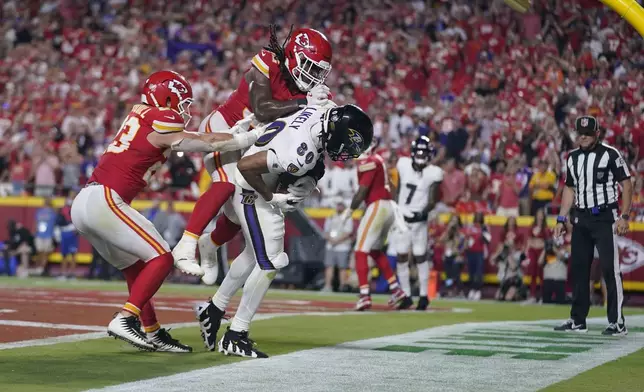 Baltimore Ravens tight end Isaiah Likely (80) catches a pass with his toe out of bounds as Kansas City Chiefs linebacker Nick Bolton and linebacker Drue Tranquill, left, defend as time time expires in the second half of an NFL football game Thursday, Sept. 5, 2024, in Kansas City, Mo. The Chiefs won 27-20.(AP Photo/Ed Zurga)