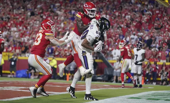 Baltimore Ravens tight end Isaiah Likely (80) catches a pass with his toe out of bounds as Kansas City Chiefs linebacker Nick Bolton and linebacker Drue Tranquill, left, defend as time time expires in the second half of an NFL football game Thursday, Sept. 5, 2024, in Kansas City, Mo. The Chiefs won 27-20.(AP Photo/Ed Zurga)