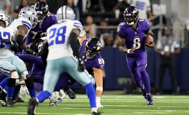 Baltimore Ravens quarterback Lamar Jackson (8) runs the ball for a first down as Dallas Cowboys safety Malik Hooker (28) and others defend late in the second half of an NFL football game in Arlington, Texas, Sunday, Sept. 22, 2024. (AP Photo/Julio Cortez)