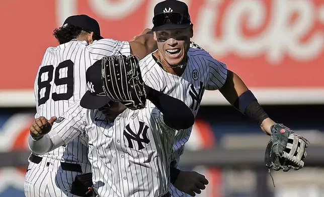 New York Yankees center fielder Aaron Judge, right, celebrates with Juan Soto, front, and Jasson Dominguez (89) after a baseball game against the Boston Red Sox, Sunday, Sept. 15, 2024, in New York. (AP Photo/Adam Hunger)