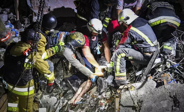 In this photo provided by the National Police of Ukraine on Sept. 3, 2024, rescue workers and police officers pull out from under the rubble an injured girl at a hotel damaged by a Russian strike in Zaporizhzhia, Ukraine. (National Police of Ukraine via AP)