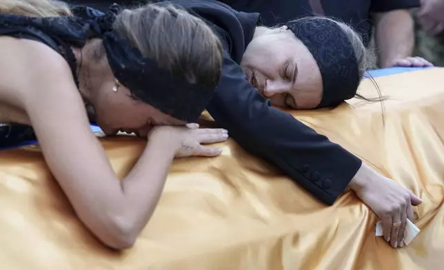 Relatives cry over the coffin of a Ukrainian serviceman killed in a Russian rocket attack at a Ukrainian military academy, during his funeral ceremony in Poltava, Ukraine, Saturday Sept. 7, 2024. (AP Photo/Evgeniy Maloletka)