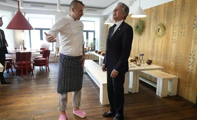 U. S. Secretary of State Antony Blinken speaks with chef Yevhen Klopotenko as he visits a restaurant in Kyiv, Ukraine, Wednesday, Sept. 11, 2024. (AP Photo/Mark Schiefelbein, Pool)