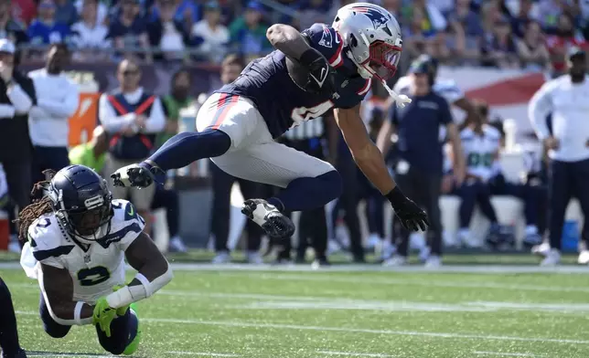 New England Patriots running back Antonio Gibson, right, is brought down by Seattle Seahawks safety Rayshawn Jenkins, left, in the second half of an NFL football game Sunday, Sept. 15, 2024, in Foxborough, Mass. (AP Photo/Michael Dwyer)