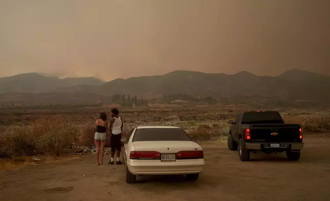 People watch as the Line Fire advances in Mentone, Calif., Sunday, Sept. 8, 2024. (AP Photo/Eric Thayer)