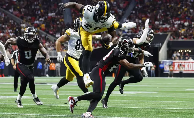 Pittsburgh Steelers running back Najee Harris (22) jumps over Atlanta Falcons cornerback Mike Hughes (21) during the second half of an NFL football game Sunday, Sept. 8, 2024, in Atlanta. (AP Photo/Butch Dill)