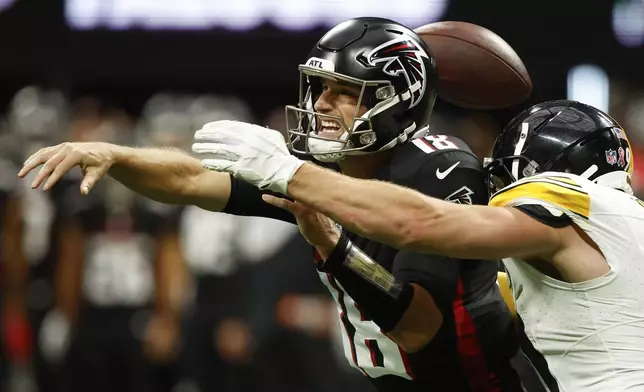 Atlanta Falcons quarterback Kirk Cousins (18) loses the ball as he is hit by Pittsburgh Steelers linebacker T.J. Watt during the second half of an NFL football game Sunday, Sept. 8, 2024, in Atlanta. (AP Photo/Butch Dill)