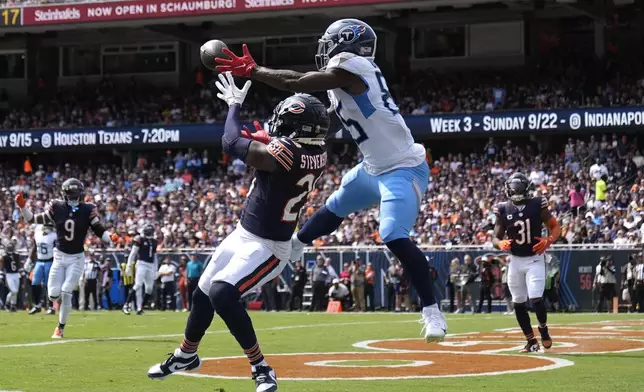 Tennessee Titans tight end Chigoziem Okonkwo catches a touchdown pass over Chicago Bears cornerback Tyrique Stevenson from quarterback Will Levis, during the first half of an NFL football game Sunday, Sept. 8, 2024, in Chicago. (AP Photo/Erin Hooley)