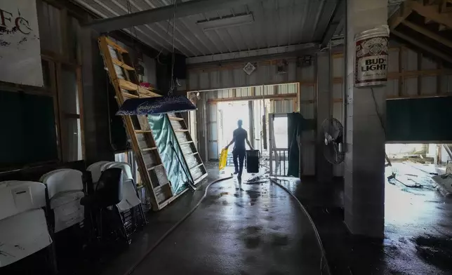 Allen McCoy helps clean out his family's camp, which took on a storm surge, in the aftermath of Hurricane Francine, in Cocodrie, La., Thursday, Sept. 12, 2024. (AP Photo/Gerald Herbert)