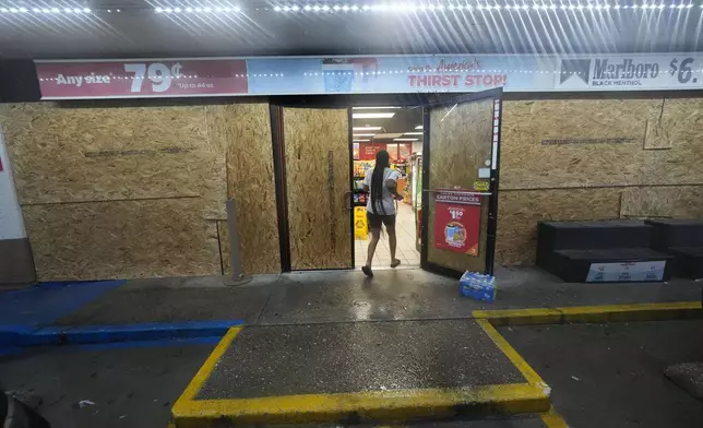 A customer enters a gas station that is boarded up in anticipation of Hurricane Francine, in Morgan City, La., Wednesday, Sept. 11, 2024. (AP Photo/Gerald Herbert)