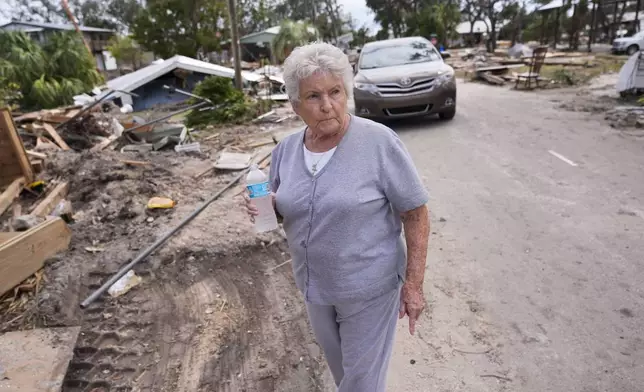 Elsie Hicks looks at the destruction of the home she has loved in for 25 years, in the aftermath of Hurricane Helene, in Horseshoe Beach, Fla., Saturday, Sept. 28, 2024. (AP Photo/Gerald Herbert)