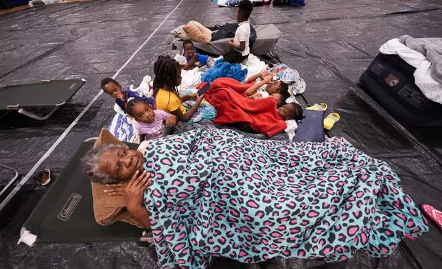 Vera Kelly, of Tallahassee, lies on a cot after evacuating to a hurricane shelter with her grandchildren and great grandchildren, at Fairview Middle School, ahead of Hurricane Helene, expected to make landfall here today, in Leon County, Fla., Thursday, Sept. 26, 2024. (AP Photo/Gerald Herbert)