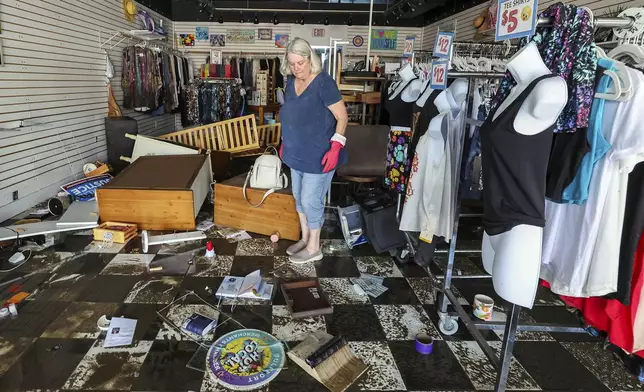 Jill Rice looks over the damage to her store caused by flooding from Hurricane Helene on Friday, Sept. 27, 2024, in Gulfport, Fla. (AP Photo/Mike Carlson)