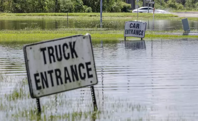 Cars drive off of Interstate 10 in Laplace, La., on Friday, Sept. 13, 2024, as floodwater still covers the roadway two days after Hurricane Francine swept through the area. (Chris Granger/The Times-Picayune/The New Orleans Advocate via AP)