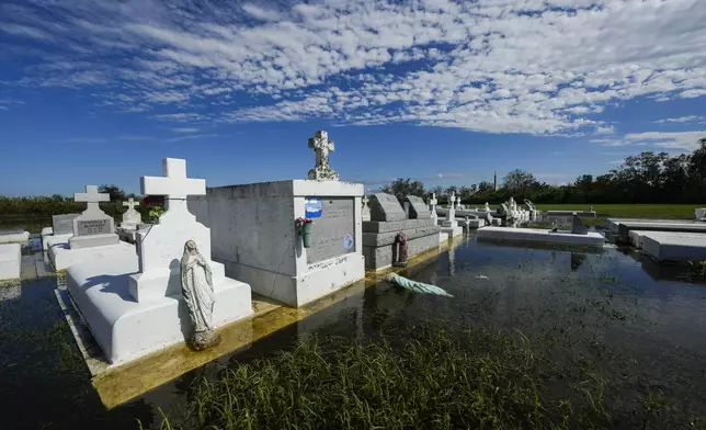 Tombs are seen after being disturbed by flooding, in the aftermath of Hurricane Francine, in Dulac, La., Thursday, Sept. 12, 2024. (AP Photo/Gerald Herbert)