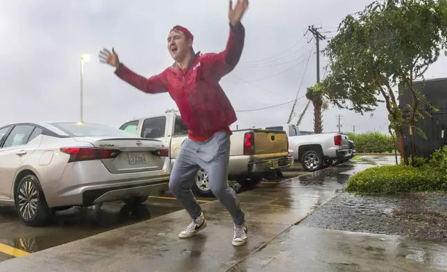 Having never before experienced the powerful forces of a hurricane, meteorologist Max Claypool of Memphis, Tenn. tries to see if the powerful winds blowing from the Hurricane Francine eye wall could lift him further in the air on Wednesday, Sept.11, 2024, Houma, La. (Chris Granger/The Times-Picayune/The New Orleans Advocate via AP)