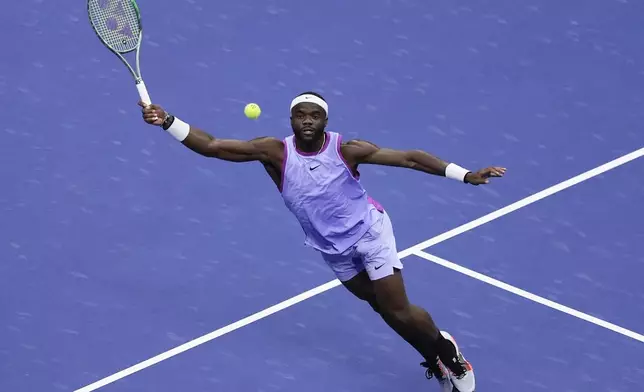 Frances Tiafoe, of the United States, reaches to return a shot from Taylor Fritz, of the United States, during the men's singles semifinal of the U.S. Open tennis championships, Friday, Sept. 6, 2024, in New York. (AP Photo/Julia Nikhinson)