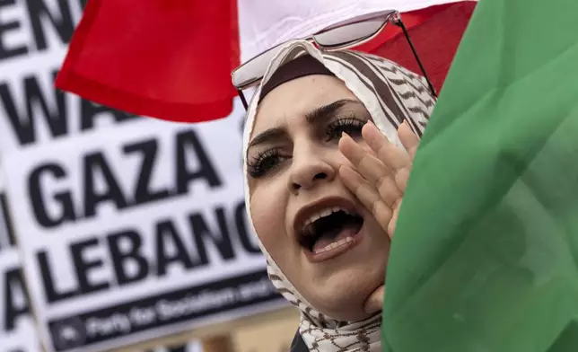 A protester waves a Lebanese flag as demonstrators gather to protest against the war on Gaza and Israeli military strikes on Lebanon in front of the Los Angeles Federal Building on Tuesday, Sept. 24, 2024, in Los Angeles. (AP Photo/Etienne Laurent)