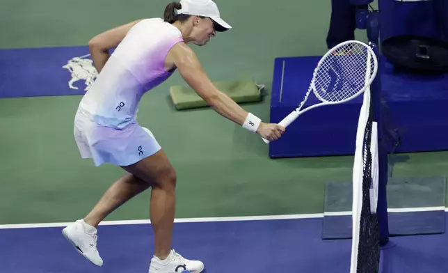 Iga Świątek, of Poland hits the net with her racquet after losing a point to Jessica Pegula, of the United States during the quarterfinals of the U.S. Open tennis championships, Wednesday, Sept. 4, 2024, in New York. (AP Photo/Adam Hunger)