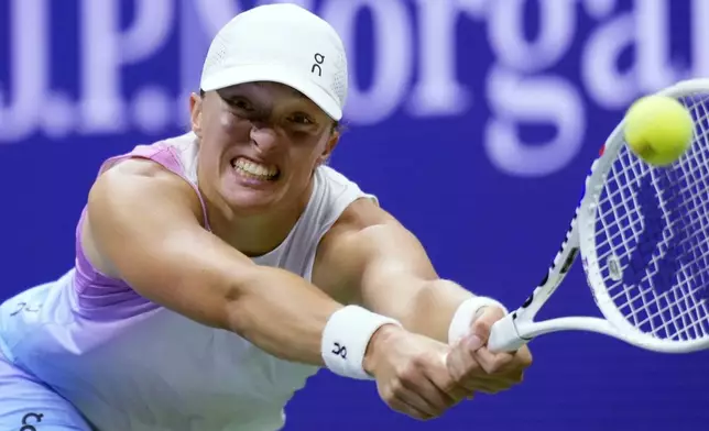 Iga Swiatek, of Poland, reaches out to hit a return to Jessica Pegula, of the United States, during the quarterfinals of the U.S. Open tennis tournament, Wednesday, Sept. 4, 2024, in New York. (AP Photo/Eduardo Munoz Alvarez)