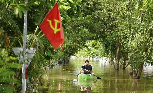 A man paddles a boat in the flood in the aftermath of Typhoon Yagi in An Lac village, Hanoi, Vietnam Friday, Sept. 13, 2024. (AP Photo/Hau Dinh)