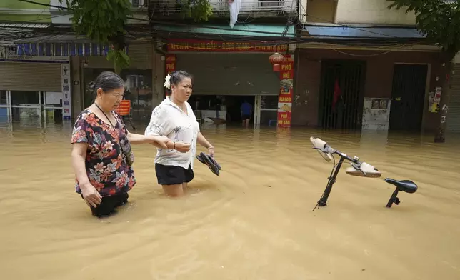 People wade in a flooded street in the aftermath of Typhoon Yagi, in Hanoi, Vietnam on Thursday, Sept. 12, 2024. (AP Photo/Hau Dinh)