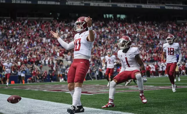 Washington State quarterback John Mateer reacts after running for a touchdown as wide receiver Kris Hutson (1) runs to greet him during the first half of an NCAA college football game against Washington, Saturday, Sept. 14, 2024, in Seattle. (AP Photo/Lindsey Wasson)