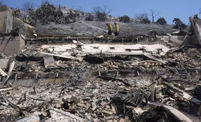 Fire crews examine a property damaged by the Airport Fire Thursday, Sept. 12, 2024, in El Cariso Village, in unincorporated Riverside County, Calif. (AP Photo/Gregory Bull)