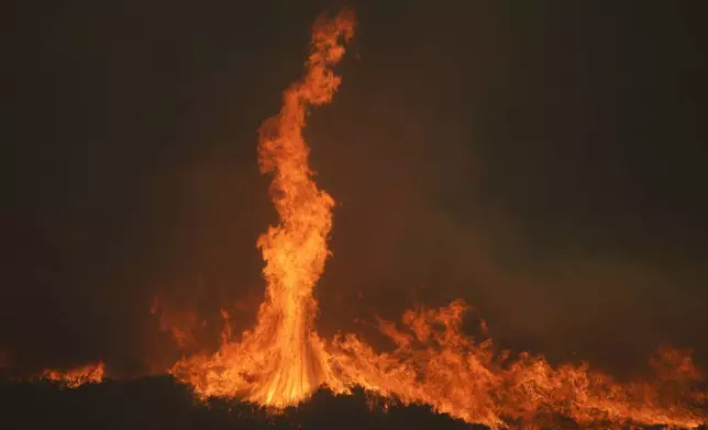 The Airport Fire burns on a mountain top Tuesday, Sept. 10, 2024, in El Cariso, an unincorporated community in Riverside County, Calif. (AP Photo/Eric Thayer)