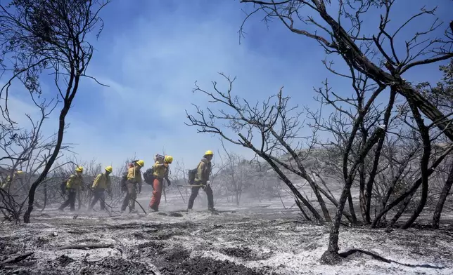 Members of Riverside County Cal Fire monitor for hot spots while battling the Airport Fire Wednesday, Sept. 11, 2024, in El Cariso Village, in unincorporated Riverside, County, Calif. (AP Photo/Gregory Bull)