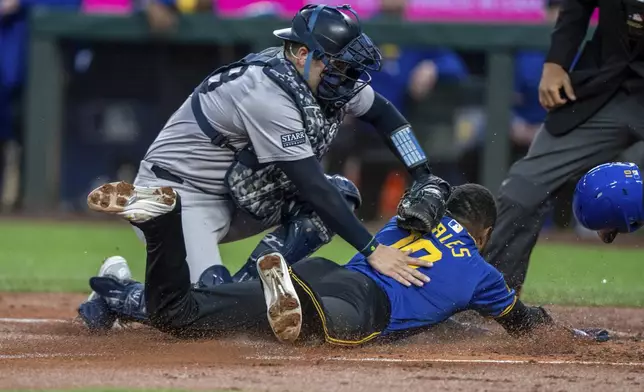 New York Yankees catcher Austin Wells tags out Seattle Mariners' Victor Robles attempting to steal home plate during the first inning of a baseball game, Tuesday, Sept. 17, 2024, in Seattle. (AP Photo/Stephen Brashear)