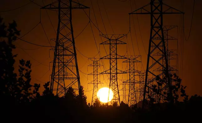 The sun sets behind high tension power lines, Monday, Sept. 23, 2024, in the Porter Ranch section of Los Angeles. (AP Photo/Mark J. Terrill)