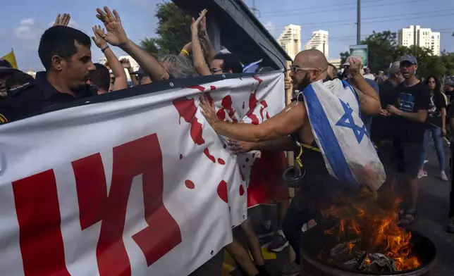 Police try to disperse demonstrators blocking a road during a protest calling for the release of hostages held in the Gaza Strip by the Hamas militant group, in Tel Aviv, Israel, Friday, Sept. 13, 2024. (AP Photo/Oded Balilty)