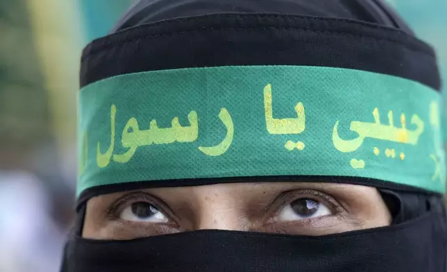 A woman wears a head scarf reading in Arabic, "my Love to Prophet Muhammad", during a parade to celebrate Moulid Al-Nabi, the birthday of the Prophet Muhammad, in Cairo, Egypt, Sunday, Sept. 15, 2024. (AP Photo/Amr Nabil)