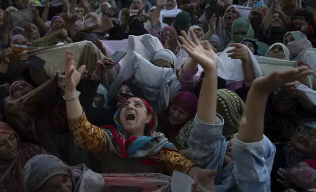 Kashmiri Muslim women devotees reacts as they offer prayers as a head priest displays a relic, believed to be a hair from the beard of the Prophet Mohammad, at the Hazratbal shrine on Eid-e-Milad, the birth anniversary of the prophet, in Srinagar, Indian controlled Kashmir, Tuesday, Sept. 17, 2024. (AP Photo/Dar Yasin)