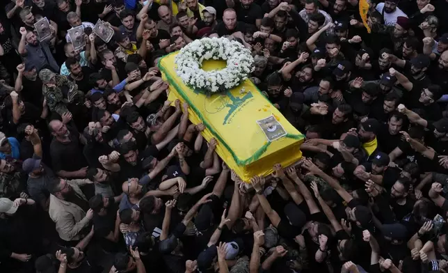 Hezbollah members carry the coffin of their comrade who was killed on Wednesday when a handheld device exploded, during a funeral procession in the southern suburbs of Beirut, Thursday, Sept. 19, 2024. (AP Photo/Hussein Malla)