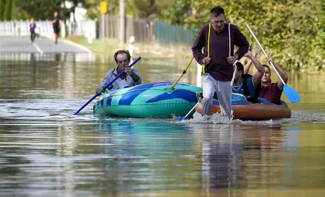 Residents paddle through a flooded street in Bohumin, Czech Republic, Tuesday, Sept. 17, 2024. (AP Photo/Darko Bandic)