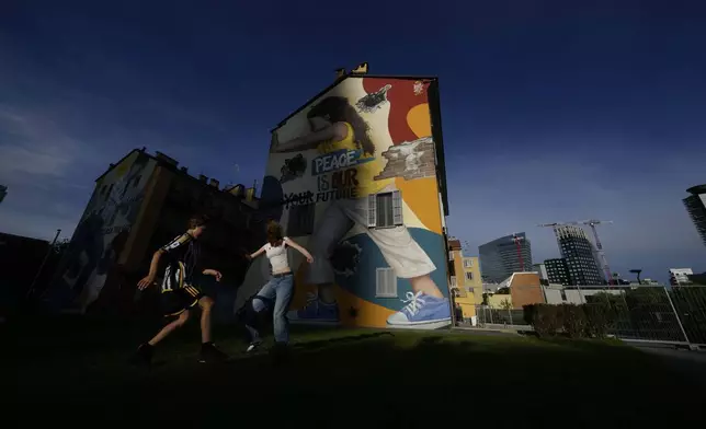 Boys play soccer in a park as the sun sets in Milan, Italy, Friday, Sept. 13, 2024. (AP Photo/Luca Bruno)