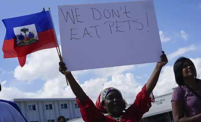 Wilda Brooks of West Palm Beach, Fla., holds up a sign reading "We don't eat pets," during a rally by members of South Florida's Haitian-American community to condemn hate speech and misinformation about Haitian immigrants, Sunday, Sept. 22, 2024, in North Miami, Fla. (AP Photo/Rebecca Blackwell)