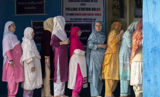 Kashmiri women queue up at a polling booth to cast their vote during the second phase of the assembly election in the outskirts of Srinagar, Indian controlled Kashmir, Wednesday, Sept. 25, 2024. (AP Photo/Dar Yasin)