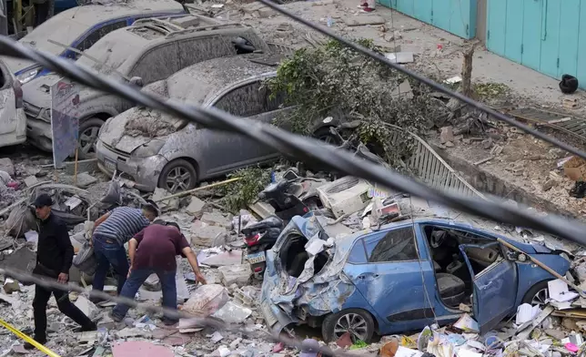 Residents check the site of an Israeli airstrike in Beirut's southern suburbs, Tuesday, Sept. 24, 2024. (AP Photo/Hassan Ammar)