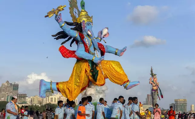 Devotees prepare to immerse a giant idol of elephant-headed Hindu god Ganesha in the Arabian Sea, marking the end of the 10-day long Ganesh Chaturthi festival in Mumbai, India, Tuesday, Sept. 17, 2024. (AP Photo/Rafiq Maqbool)