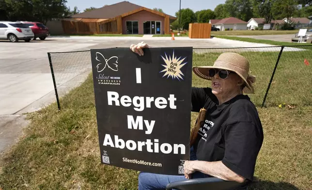 Anti-abortion protester Deborah Green-Myers, from Pittsburg, Kan., demonstrates outside a recently opened Planned Parenthood clinic, Tuesday, Sept. 10, 2024, in Pittsburg, Kan. (AP Photo/Charlie Riedel)